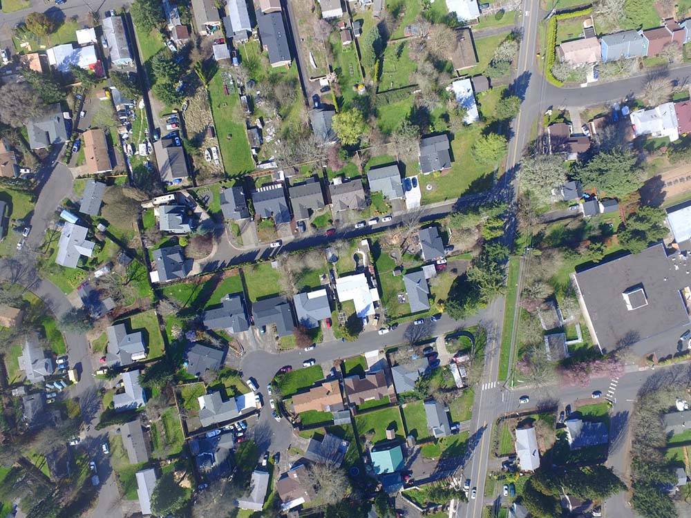 An aerial view of a community displays the many residential and commercial buildings below.